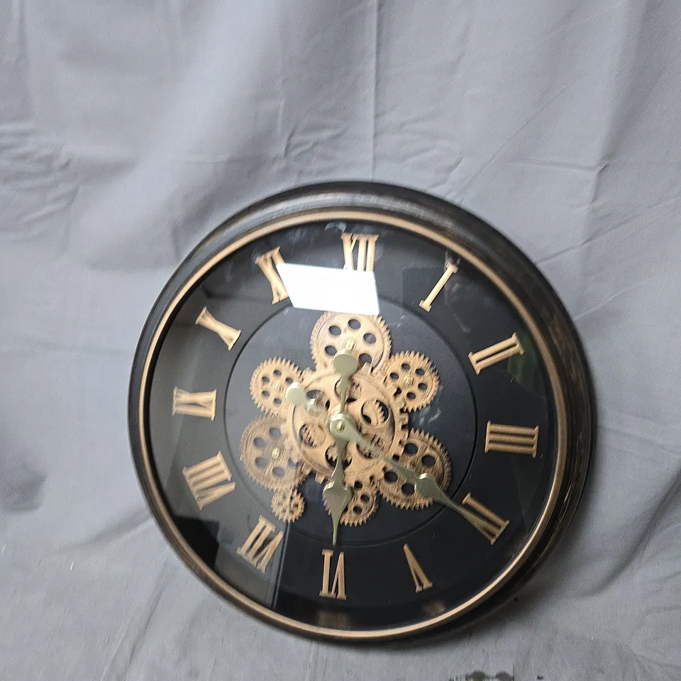 ROUND WALL CLOCK WITH EXPOSED GEARS, BLACK DIAL AND ROMAN NUMERALS