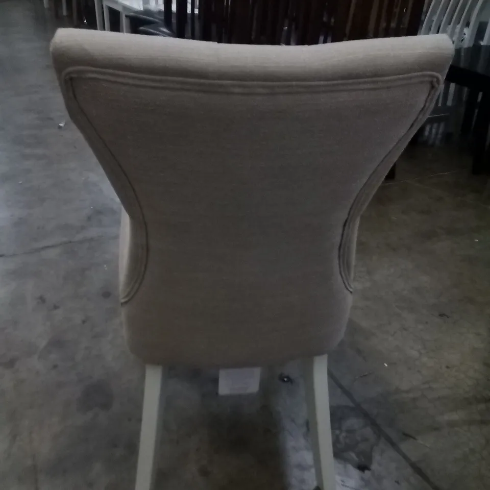 APPROXIMATELY 4 BEIGE FABRIC BUTTON BACK DINING CHAIRS WITH WHITE LEGS