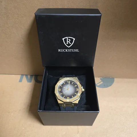 RUCKSTUHL BLACK RUBBER STRAP WRISTWATCH WITH GOLD COLOUR FRAME AND BLACK/SILVER COLOUR FACE 