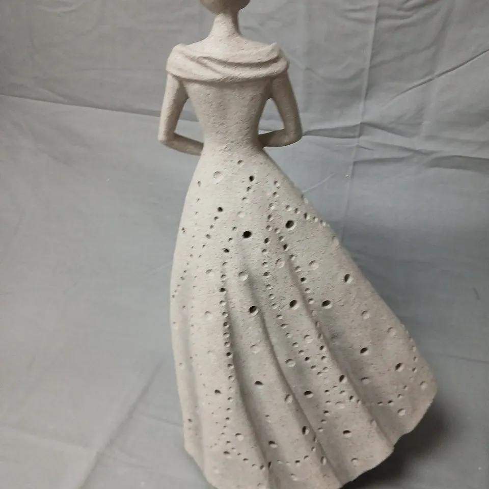Ceramic sculpture of standing woman in a dotted gown