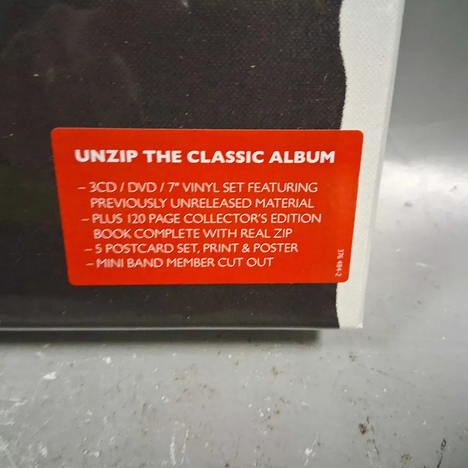 BOXED AND SEALED THE ROLLING STONES STICKY FINGERS UNZIP THE CLASSIC ALBUM INCLUDE; 3CD/DVD/7" VINYL SET, 120 PAGE COLLECTOR'S EDITION BOOK, 5 POSTCARD SET, PRINT AND POSTER AND MINI BAND MEMBER CUT O