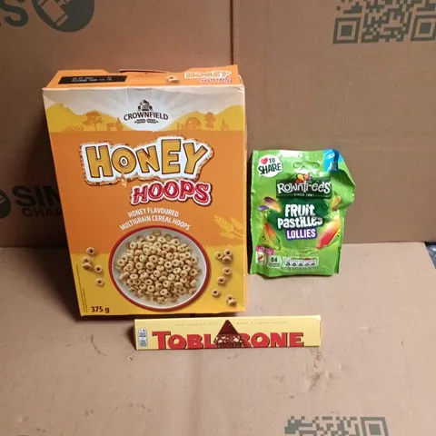 APPROXIMATELY 12 ASSORTED FOOD AND DRINKS ITEMS TO INCLUDE - FRUIT PASTILLES LOLLIES SWEETS, TOBLARONE BAR, HONEY HOOPS CEREAL ETC 