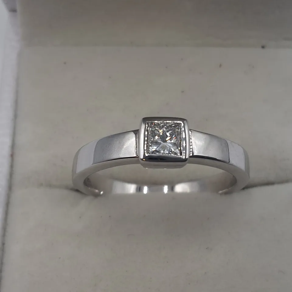 18CT WHITE GOLD SOLITAIRE RING SET WITH A NATURAL RUB OVER DIAMOND