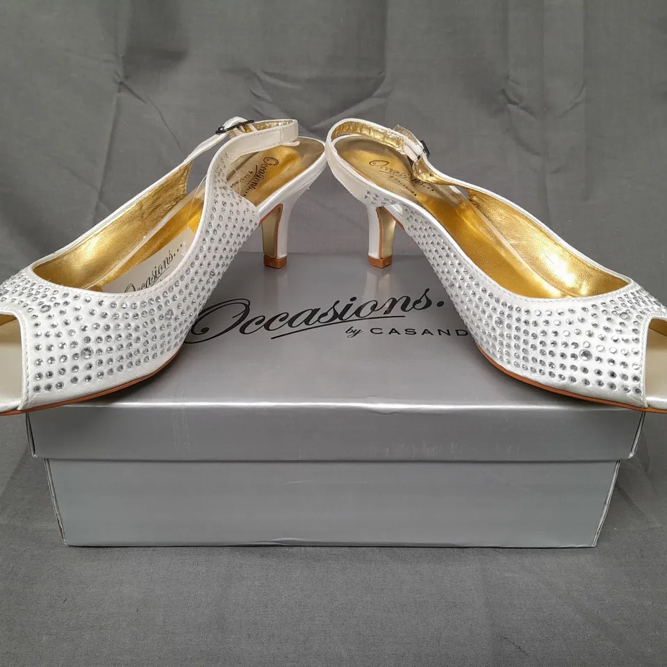 BOXED PAIR OF OCCASIONS BY CASANDRA OPEN TOE LOW HEEL ANKLE STRAP SHOES IN IVORY SATIN W. JEWEL EFFECT SIZE 7