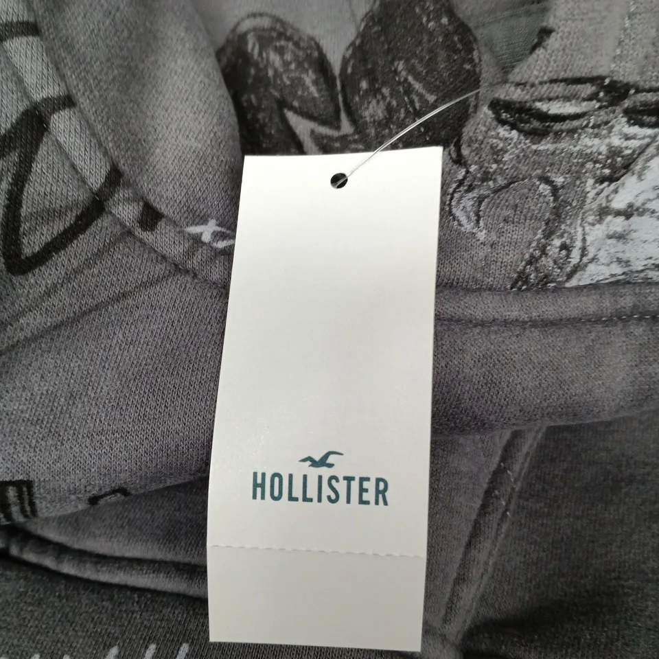 HOLLISTER HOODIE – GREY WITH ALL-OVER GRAPHIC PRINT, SIZE LARGE