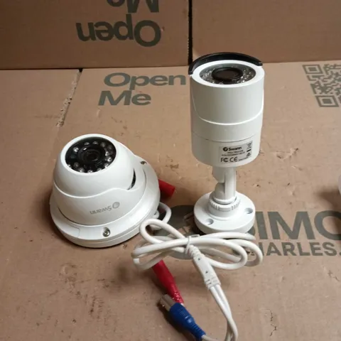BOX OF SWANN HOME SECURITY CAMERAS WITH ACCESSORIES PRO-T852CAM AND PRO-T854CAM