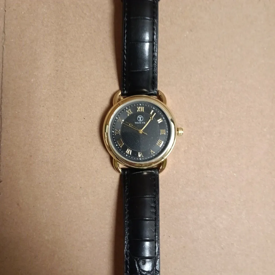 BOXED TALIS CO. WRISTWATCH GOLD-TONE, BLACK DIAL WITH ROMAN NUMERALS, BLACK LEATHER STRAP