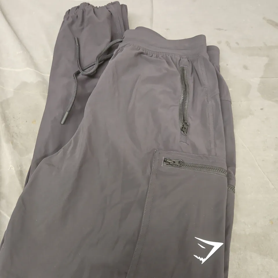 GYMSHARK GREY SOFTSHELL TROUSERS WITH ZIP POCKETS AND DRAWSTRING WAIST SIZE S