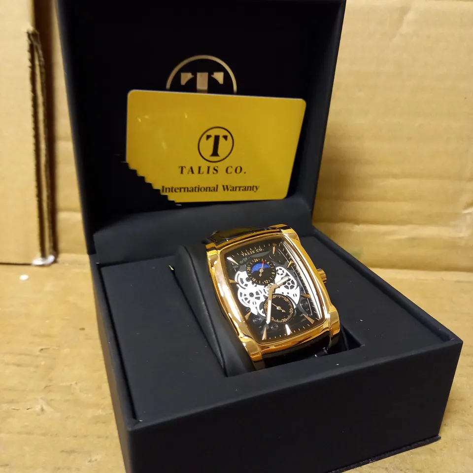 MENS TALIS CO WATCH, CHRONOGRAPH MOVEMENT. BLACK LEATHER STRAP, GOLD FRAME, SLEEK BLACK/SILVER SKELETON DIAL