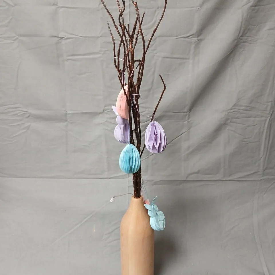 Decorative twig tree in wooden vase with pastel honeycomb ornaments