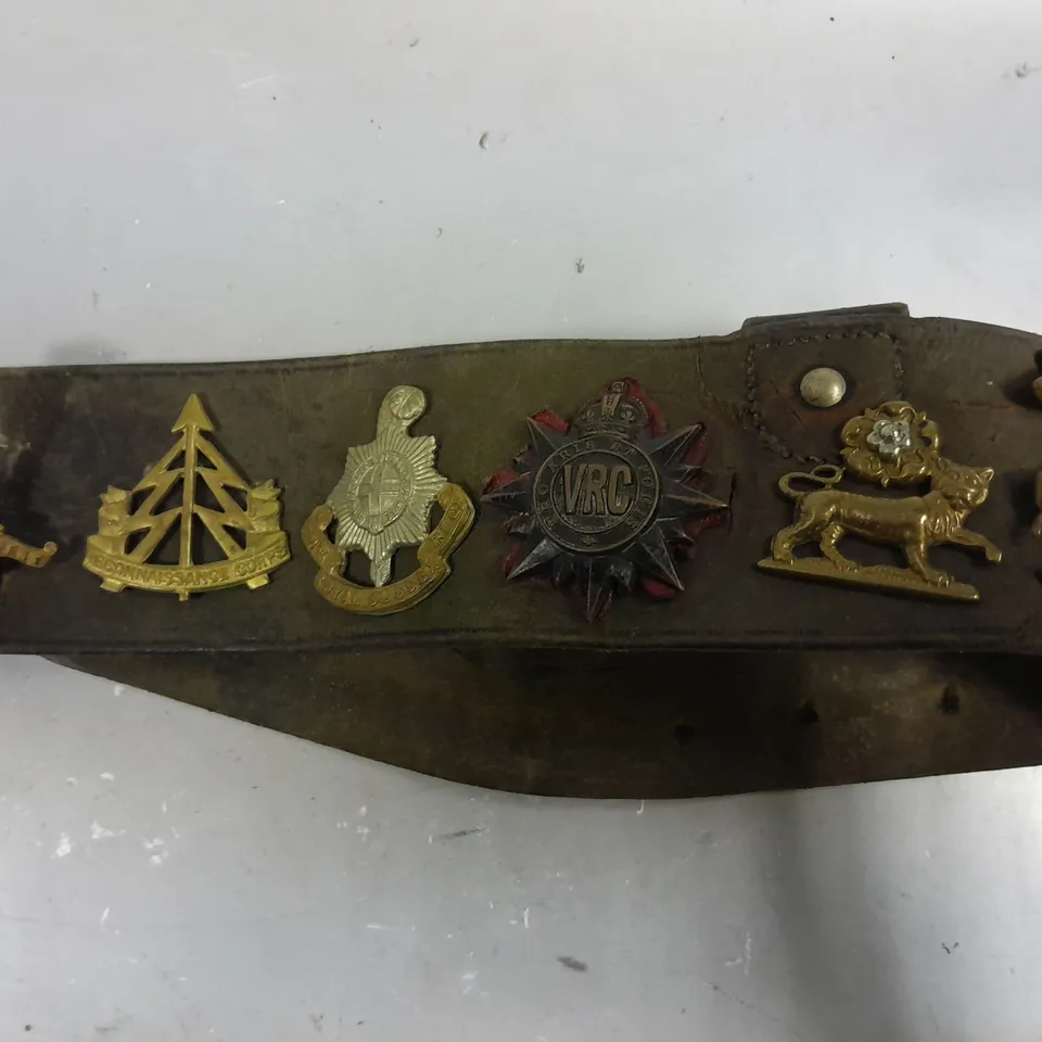 VINTAGE BELT WITH ASSORTED WW1/WW2 BRITISH ARMY CAP BADGES 