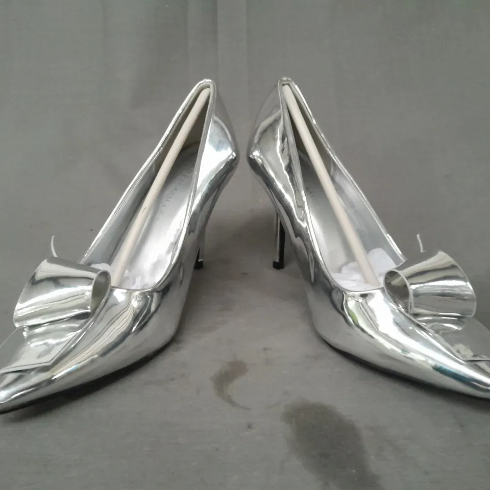 BOXED PAIR OF KAREN MILLEN TWIST BOW DETAIL POINTED TOE HEELS IN METALLIC SILVER SIZE 6