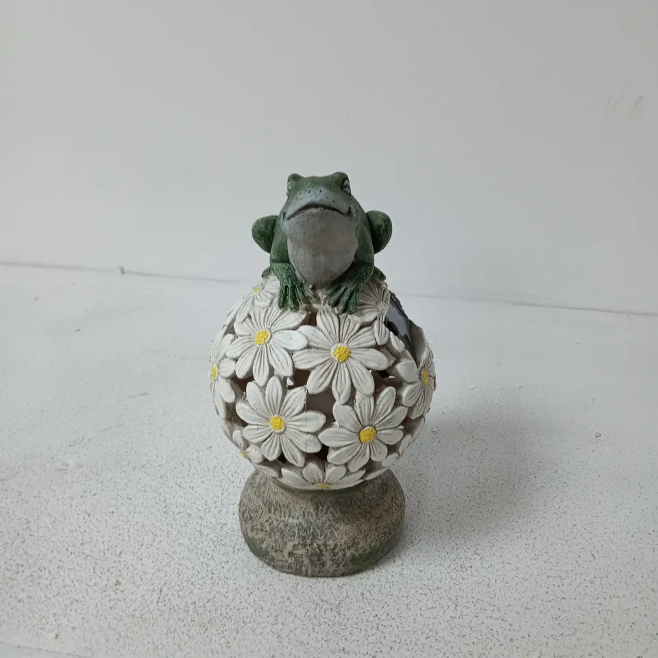 SOLAR LIGHT CERAMIC FROG FIGURINE PERCHED ON A DAISY-BALL PEDESTAL