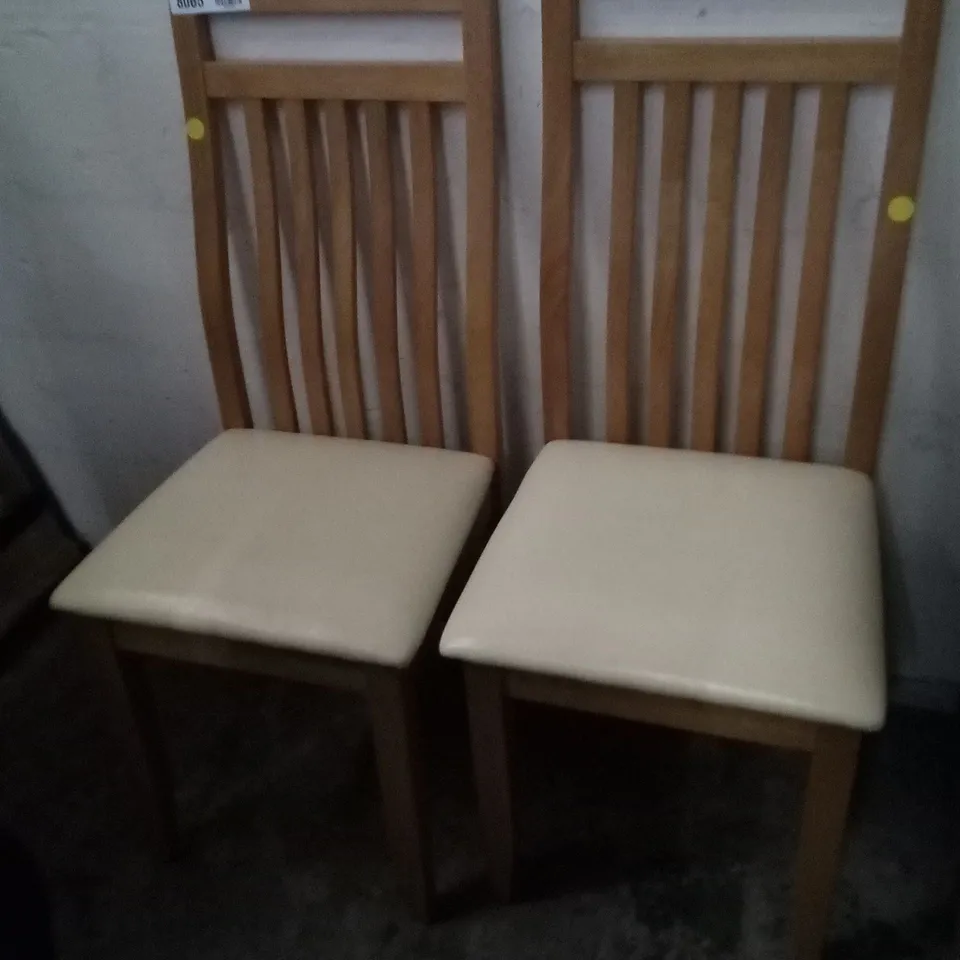 PAIR OF OAK EFFECT SLATTED BACK DINING CHAIRS WITH CREAM FAUX LEATHER SEAT PAD