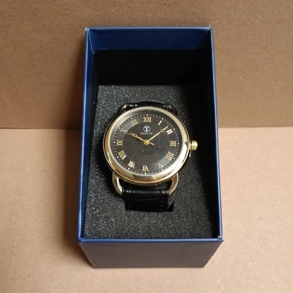 BOXED TALIS CO. WRISTWATCH GOLD-TONE, BLACK DIAL WITH ROMAN NUMERALS, BLACK LEATHER STRAP