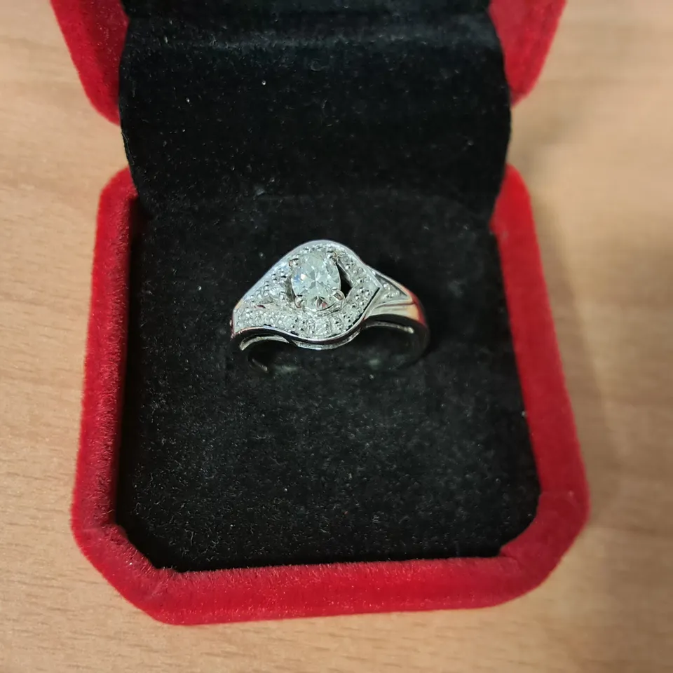 18CT WHITE GOLD RING SET WITH A NATURAL OVAL CUT DIAMOND TO NATURAL DIAMOND HALO