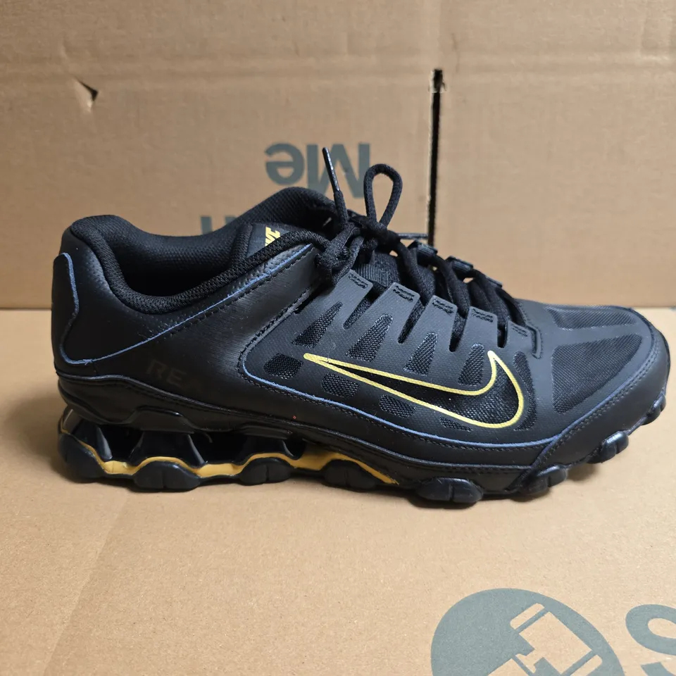 UNBOXED PAIR OF NIKE TRAINING REAX TRAINERS IN BLACK/GOLD - UK 8.5