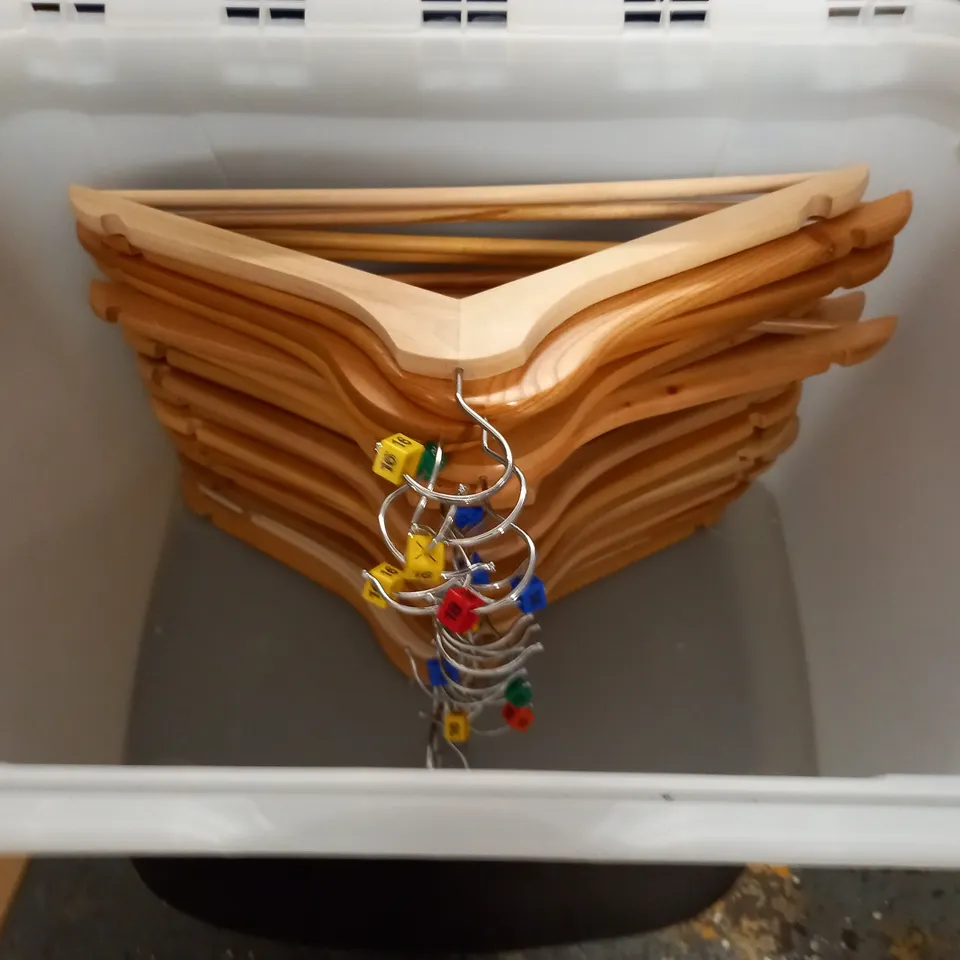 large quantity of assorted wooden clothes hangers in plastic crate