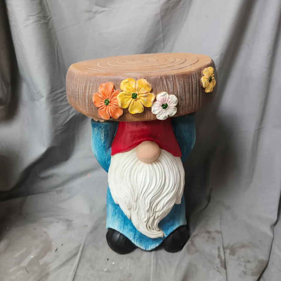 GARDEN GNOME STATUE CARRYING A FLOWER-DECORATED ROUND TOP. 45CM HEIGHT