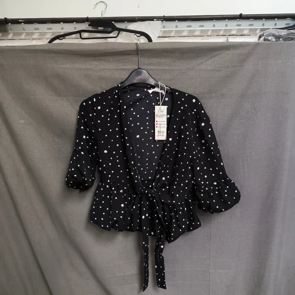 BOX OF APPROXIMATELY 50 URBAN BLISS WOMEN'S BLACK POLKA DOT WRAP BLOUSE WITH TIE-WAIST - SIZES 8 / 10 /12 / 14 