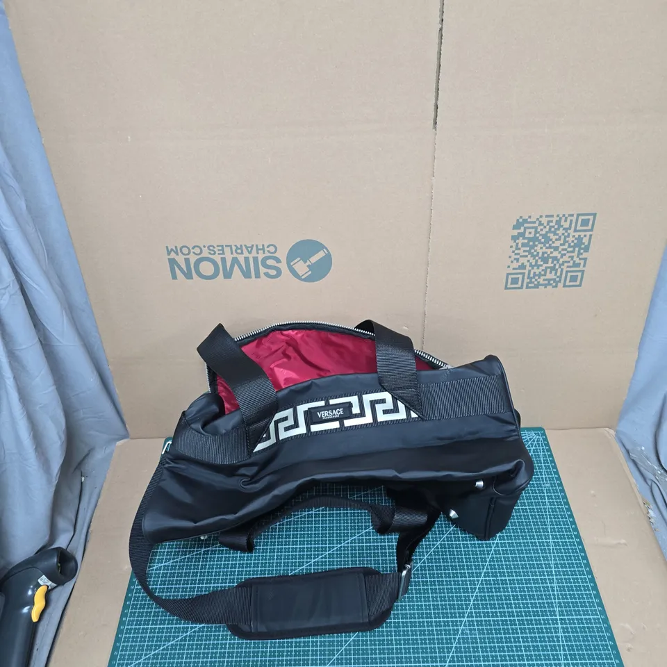 VERSACE FRAGRANCES BLACK DUFFEL BAG WITH GREEK KEY STRAP AND PINK LINING