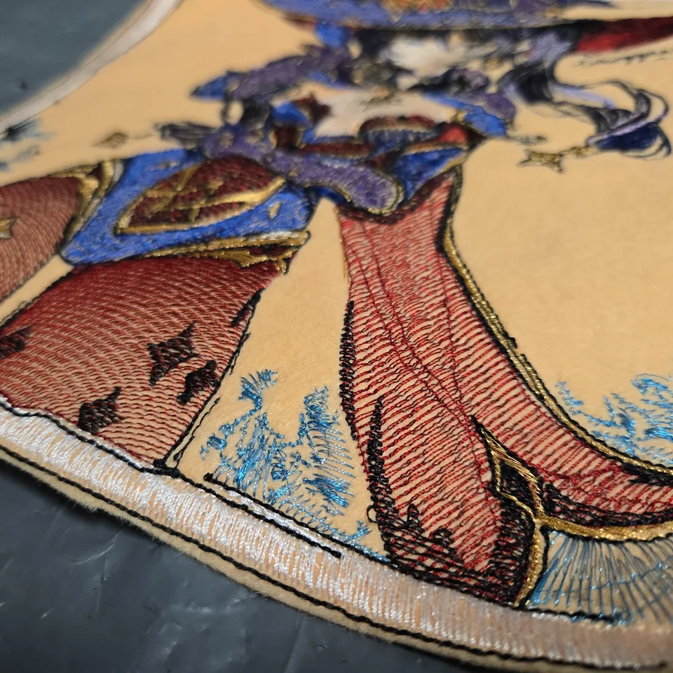 EMBROIDERED FANTASY CHARACTER PATCH ON BEIGE FABRIC