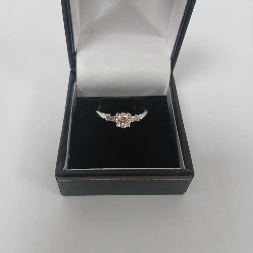18CT WHITE GOLD RING SET WITH A NATURAL DIAMOND AND A BAGUETTE TO EACH SHOULDER
