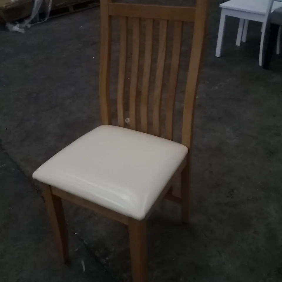 APPROXIMATELY 4 OAK EFFECT SLATTED BACK DINING CHAIRS WITH CREAM FAUX LEATHER SEAT PADS