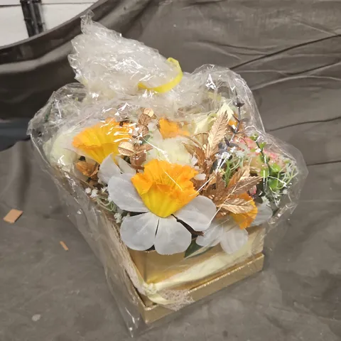 ARTIFICIAL FLOWER ARRANGEMENT IN GOLD BASE, WRAPPED IN CLEAR PLASTIC