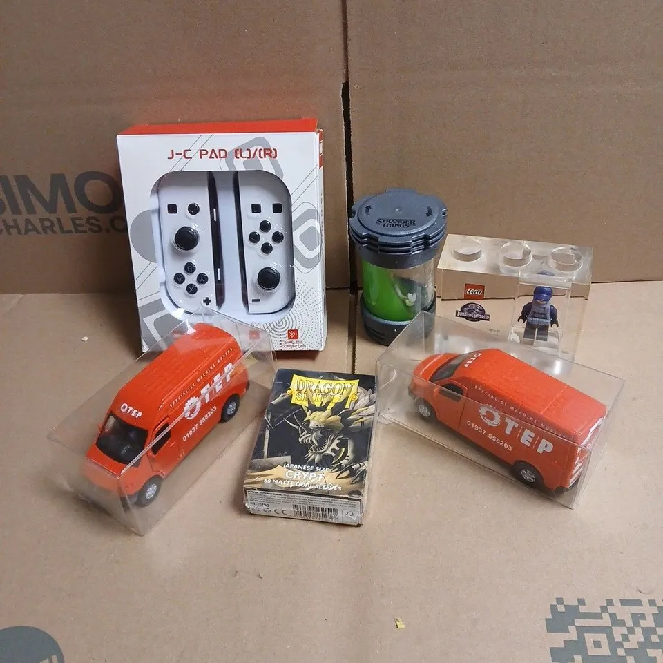 TOTE OF APPROXIMATELY 20 ASSORTED TOYS/RELATED ITEMS TO INCLUDE J-C PAD, LEGO JURASSIC WORLD TOY, STRANGERS THINGS TOY, ADTRUCKS OTEP RED VAN MODELS ETC