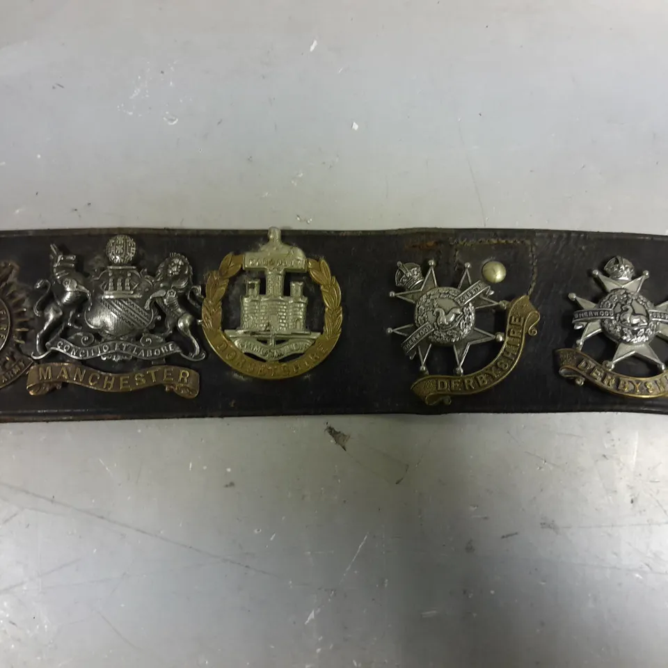VINTAGE BELT WITH ASSORTED WW1/WW2 BRITISH ARMY CAP BADGES 