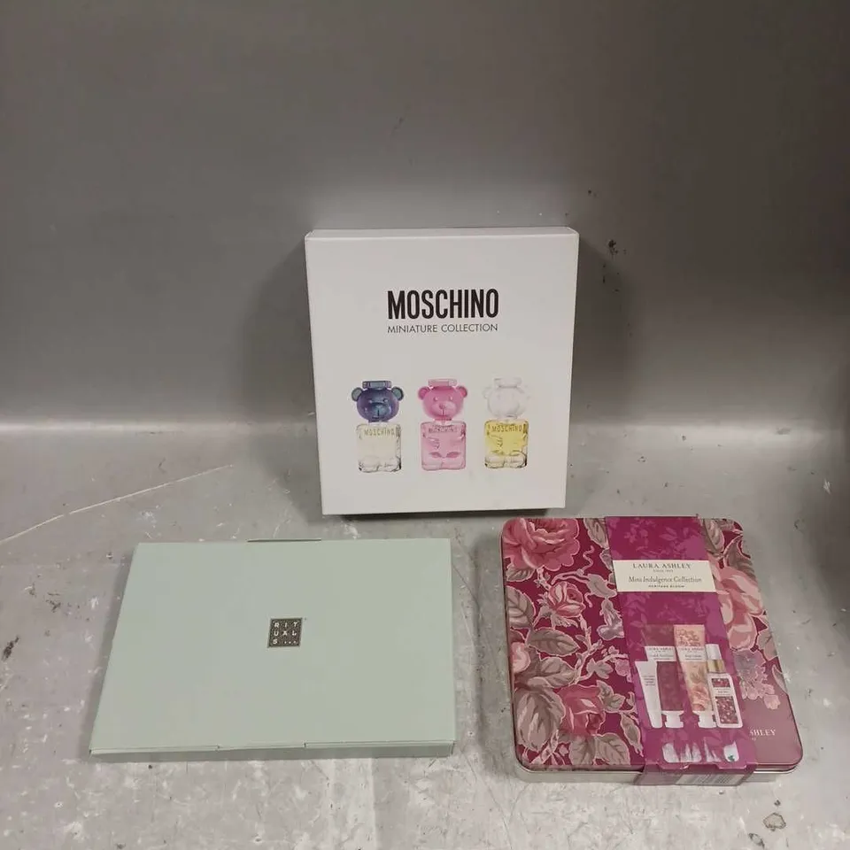 LOT OF 3 ASSORTED COSMETIC BOXSETS TO INCLUDE - RITUALS HAND CARE KIT - MOSCHINO MINIATURE FRAGRANCE COLLECTION - LAURA ASHLEY MINI INDULGENCE COLLECTION