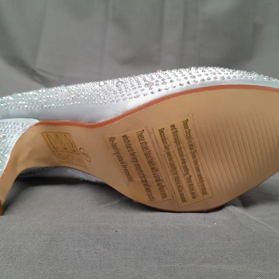 BOX OF APPROXIMATELY 10 BOXED PAIRS OF OCCASIONS BY CASANDRA CLOSED TOE MID HEEL SHOES IN SILVER SATIN W. JEWEL EFFECT - VARIOUS SIZES