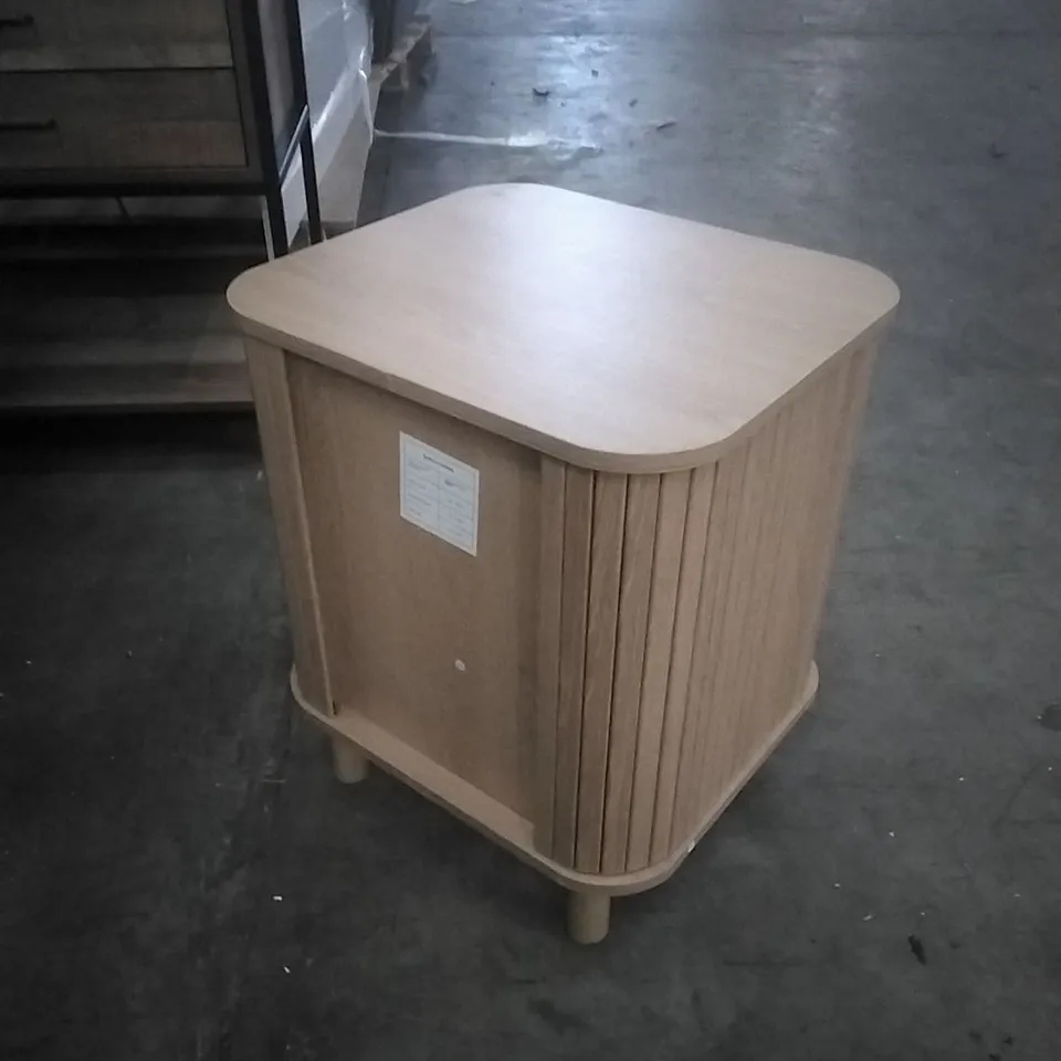 SUIRE LIGHT WOOD BEDSIDE TABLE, FEATURING ROUNDED CORNERS AND FLUTED DRAWER FRONTS