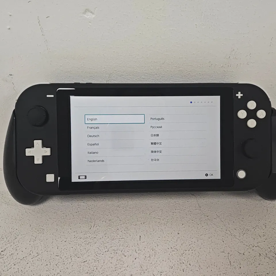 UNBOXED NINTENDO SWITCH LITE HANDHELD GAMING CONSOLE IN BLACK WITH ATTACHED CONTROLLER SUPPORT