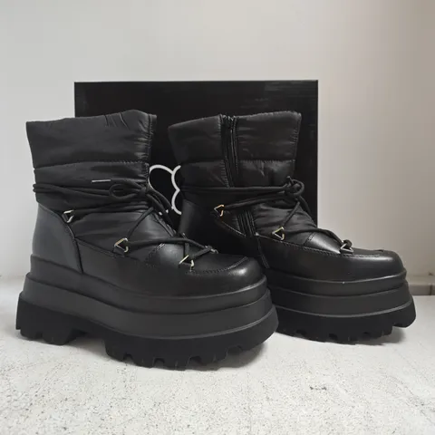 BOXED PAIR OF CHUNKY PADDED PLATFORM ANKLE BOOTS IN BLACK SIZE 4