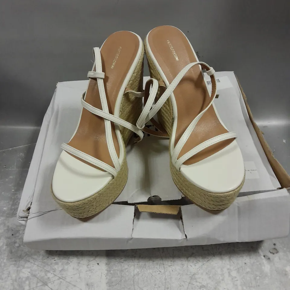 BOXED PAIR OF PRETTYLITTLETHING PU ROUND TOE ASYMMETRIC STRAP WEDGE SHOWS IN WHITE MIX SIZE 5