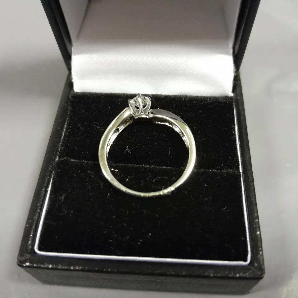 18CT WHITE GOLD TWIST RING SET WITH A NATURAL DIAMOND BAGUETTE SHOULDERS