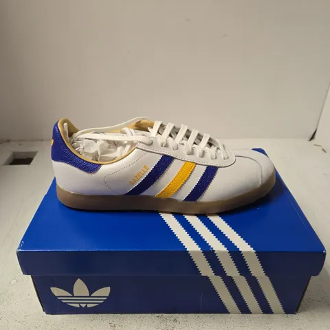 ADIDAS GAZELLE GOLF TRAINERS – WHITE WITH BLUE/YELLOW STRIPES, UK 9.5