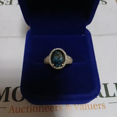DIAMONIQUE BLUE OVAL GEMSTONE RING WITH HALO IN WHITE METAL