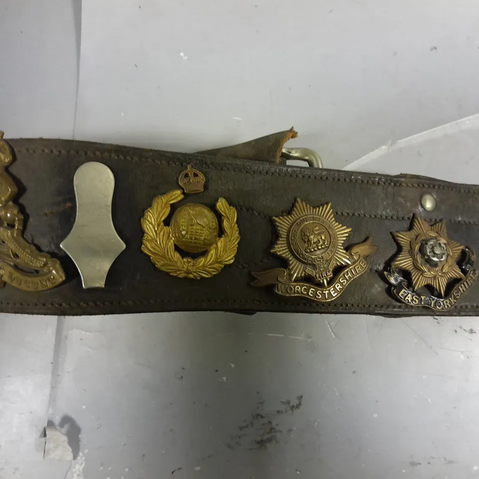 VINTAGE BELT WITH ASSORTED WW1/WW2 BRITISH ARMY CAP BADGES 