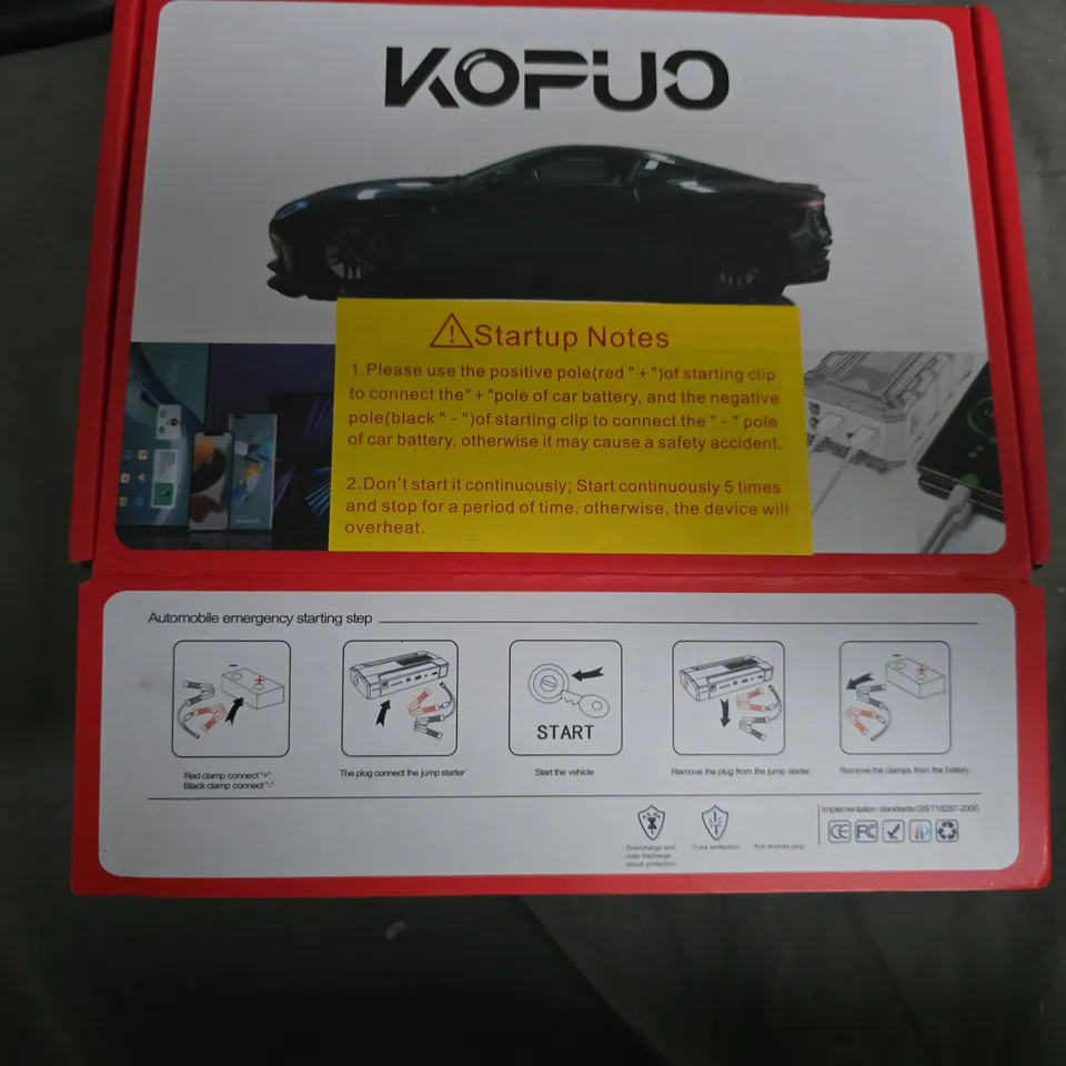 PORTABLE CAR JUMP STARTER – BLACK HANDHELD DEVICE IN RED BOX 