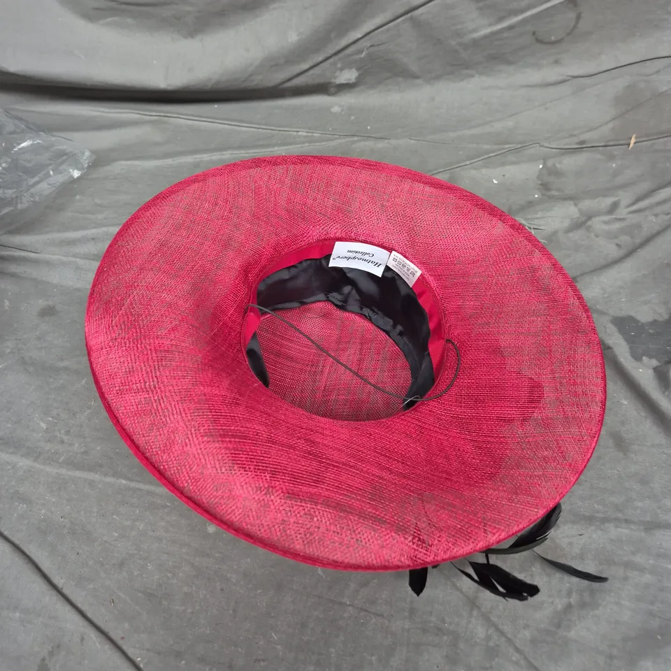 RED WIDE-BRIM HAT WITH BOW AND BLACK LEAF ACCENTS