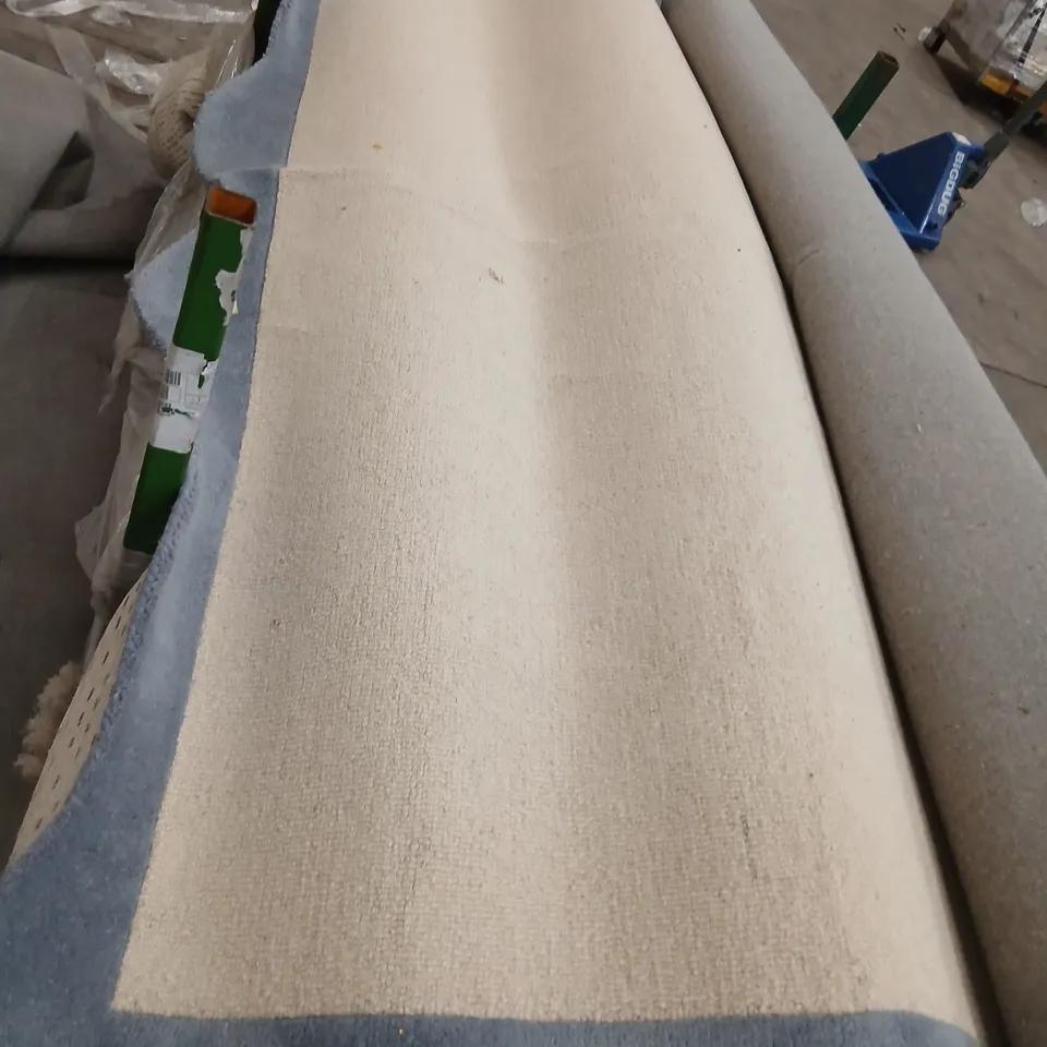 LARGE CREAM RUG WITH BLUE BORDER AND WAVY EDGES