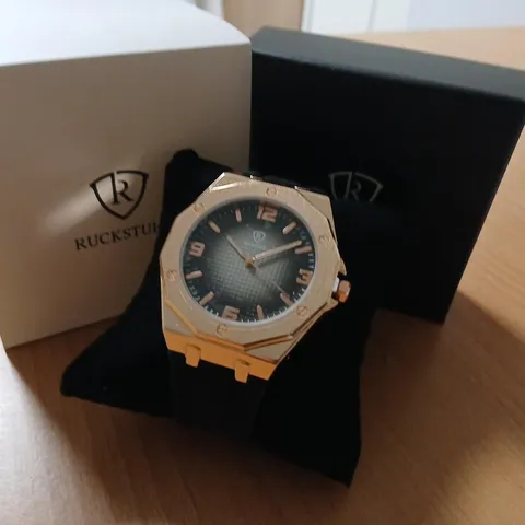 RUCKSTUHL WRISTWATCH – ROSE GOLD-TONE CASE, BLACK STRAP, BLACK DIAL