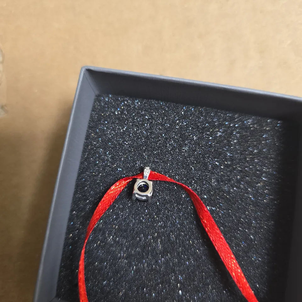 ANGARA BLUE GEMSTONE PENDANT ON RED CORD – BOXED