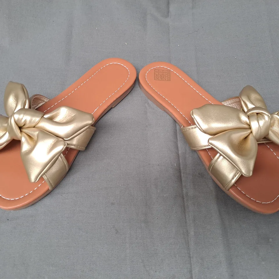 BOXED PAIR OF DESIGNER OPEN TOE FLAT SANDALS IN METALLIC GOLD W. BOW DETAIL EU SIZE 35