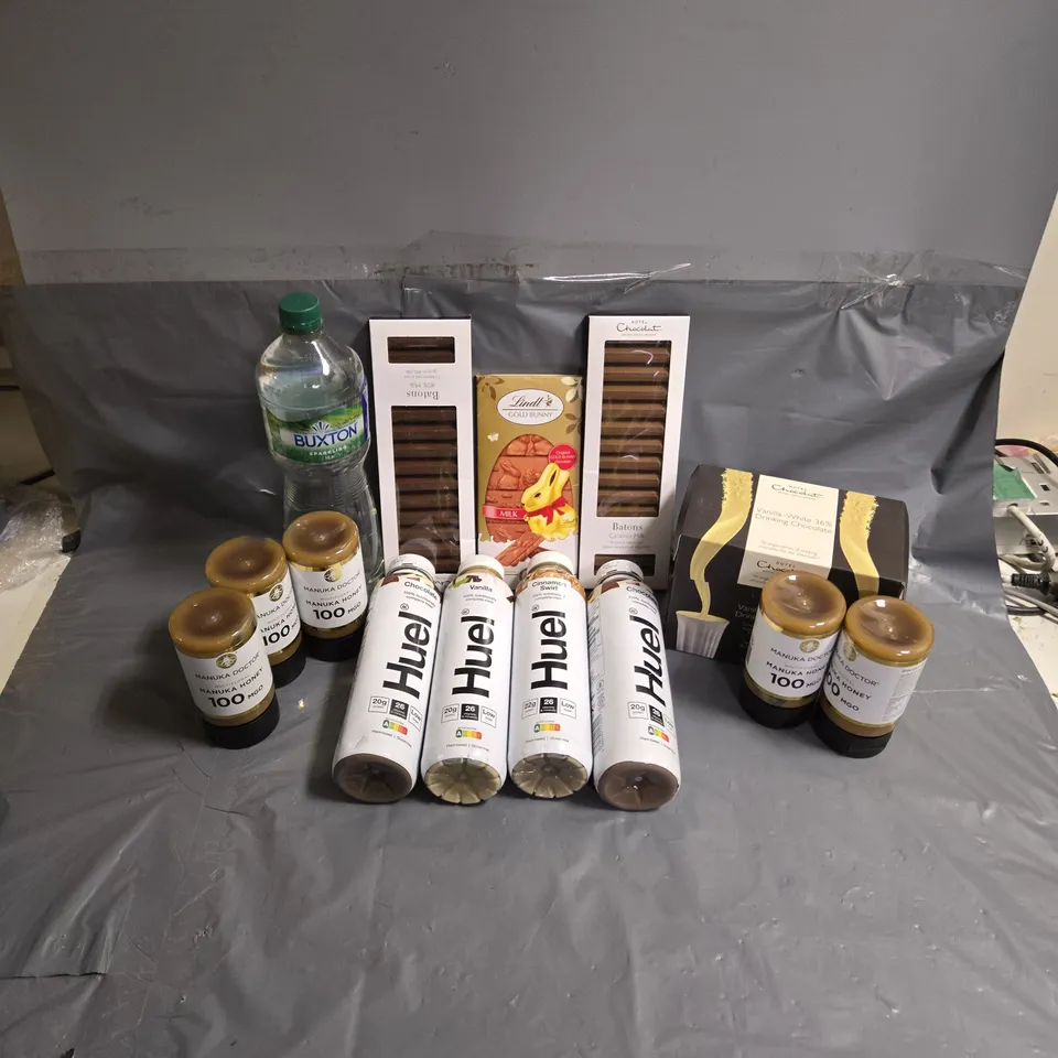 APPROXIMATELY 12 ASSORTED FOOD & DRINK ITEMS TO INCLUDE HUEL CHOCOLATE DRINK, MANUKA DOCTOR MANUKA HONEY 100MGO, HOTEL CHOCOLAT BATONS, ETC