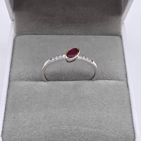 18CT GOLD RING WITH AN OFFSET OVAL CUT RUBY & NATURAL DIAMONDS TO THE SHOULDER