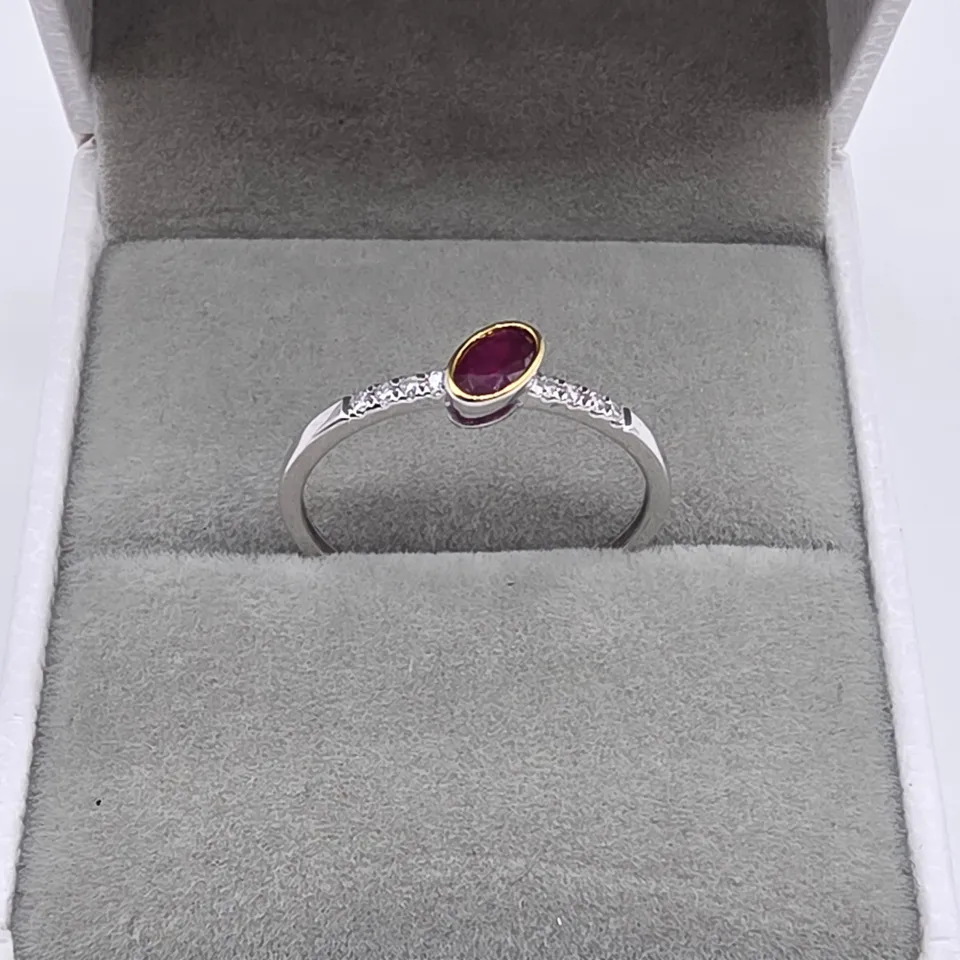18CT GOLD RING WITH AN OFFSET OVAL CUT RUBY & NATURAL DIAMONDS TO THE SHOULDER